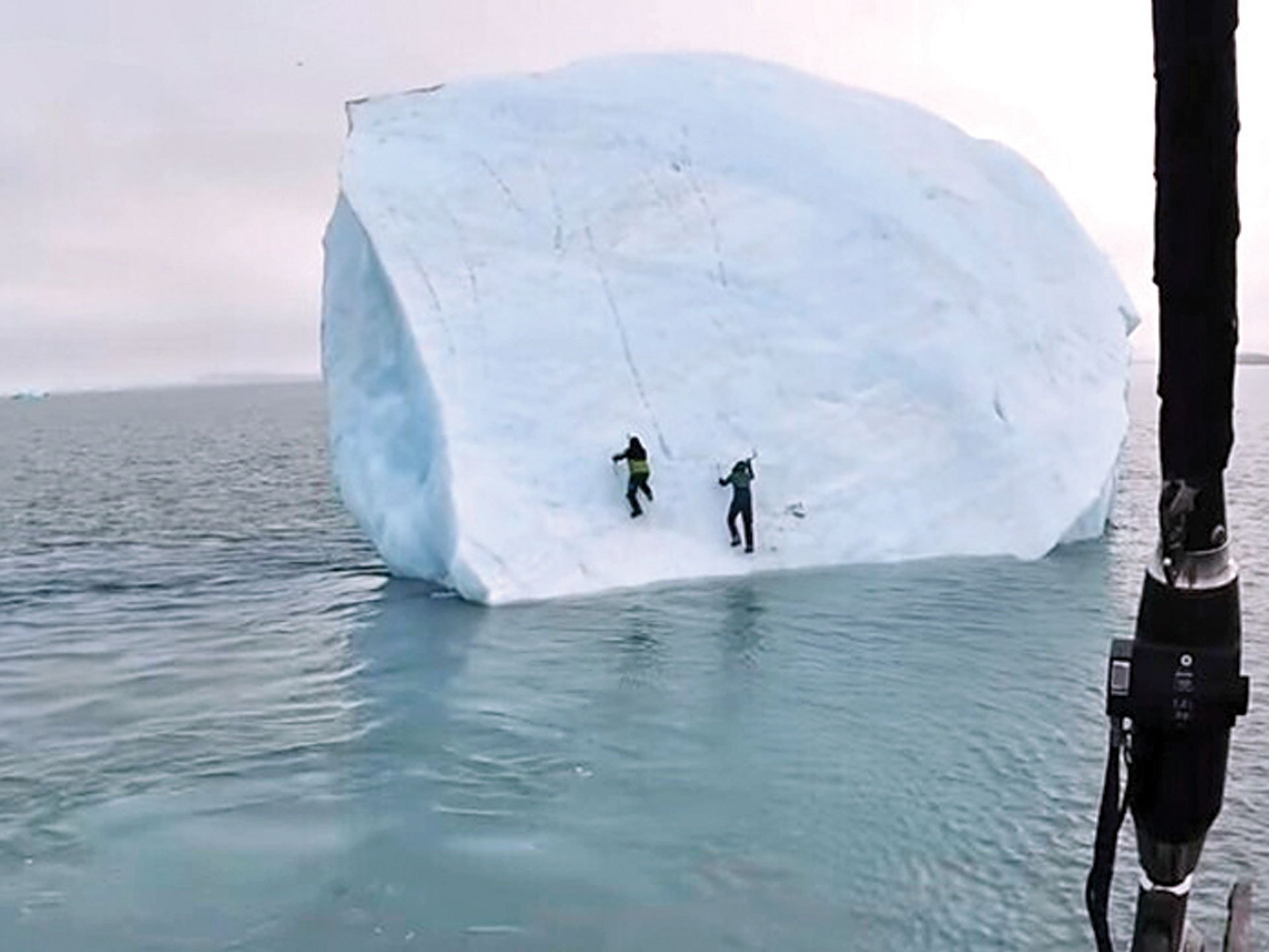 An iceberg turns over on two adventurers in the Arctic Ocean